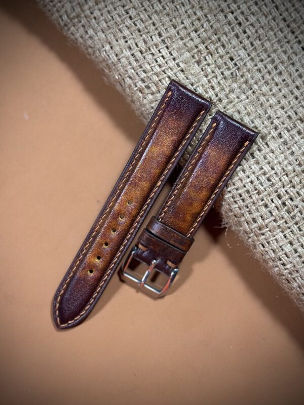 Hand-dyed vegetable-tanned leather watch strap in brown with detailed stitching and a polished buckle