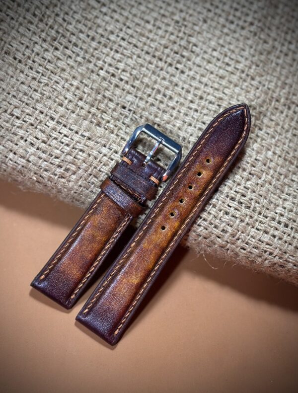 Hand-dyed vegetable-tanned leather watch strap in brown with detailed stitching and a polished buckle