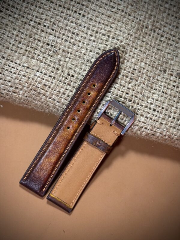 Hand-dyed vegetable-tanned leather watch strap in brown with detailed stitching and a polished buckle