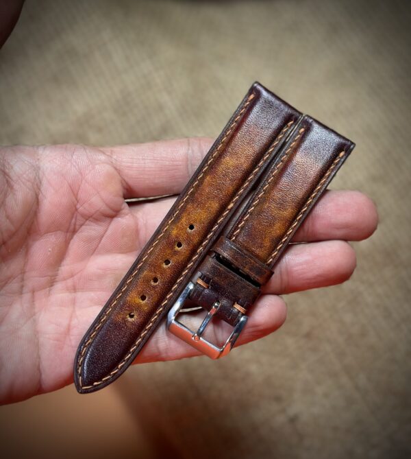 Hand-dyed vegetable-tanned leather watch strap in brown with detailed stitching and a polished buckle